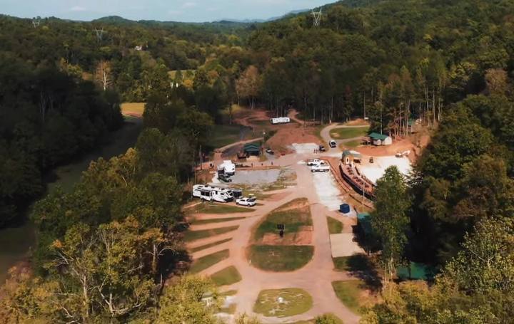 Aerial view of the resort: gravel loops and clearings cut into the trees, with buildings near the entrance